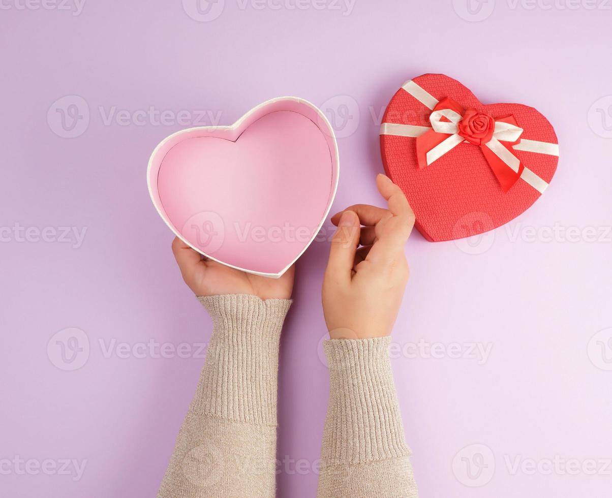 girl opens a red gift  box on a purple background photo