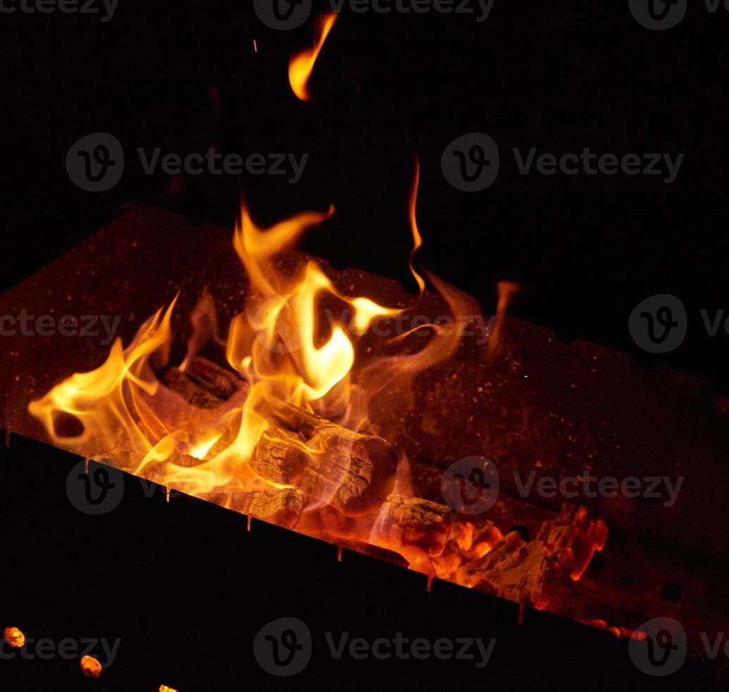 burning wooden logs in the fire at night photo