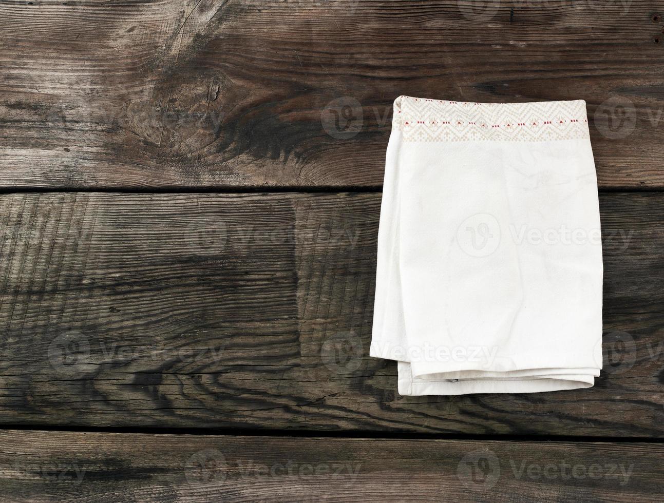 white kitchen textile towel folded on a gray wooden table from old boards, top view, empty space photo