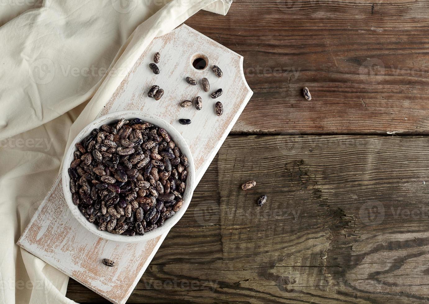 raw oval red marble beans in a plate on a wooden table photo