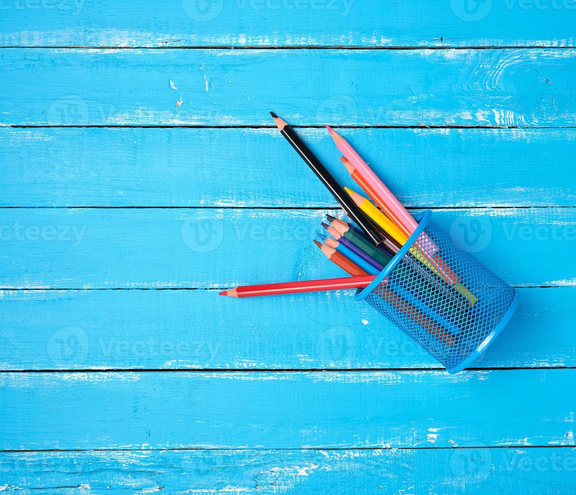 blue stationery glass with multi-colored wooden pencils photo