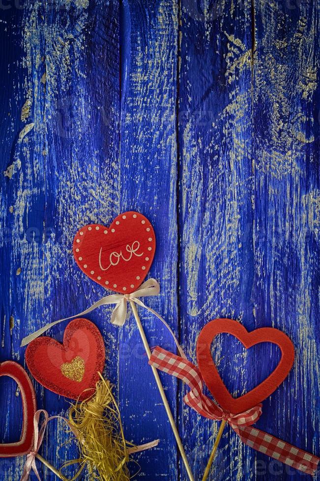 Wooden blue background with red wooden hearts photo