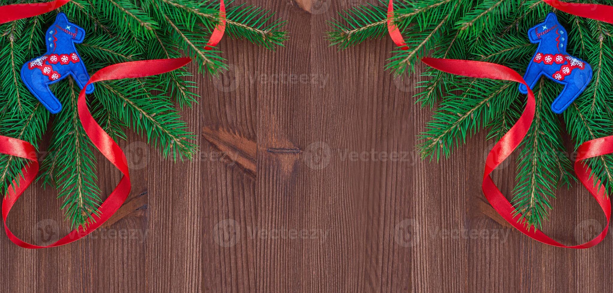 Christmas background with branches of fir and decorations on a brown wooden background photo