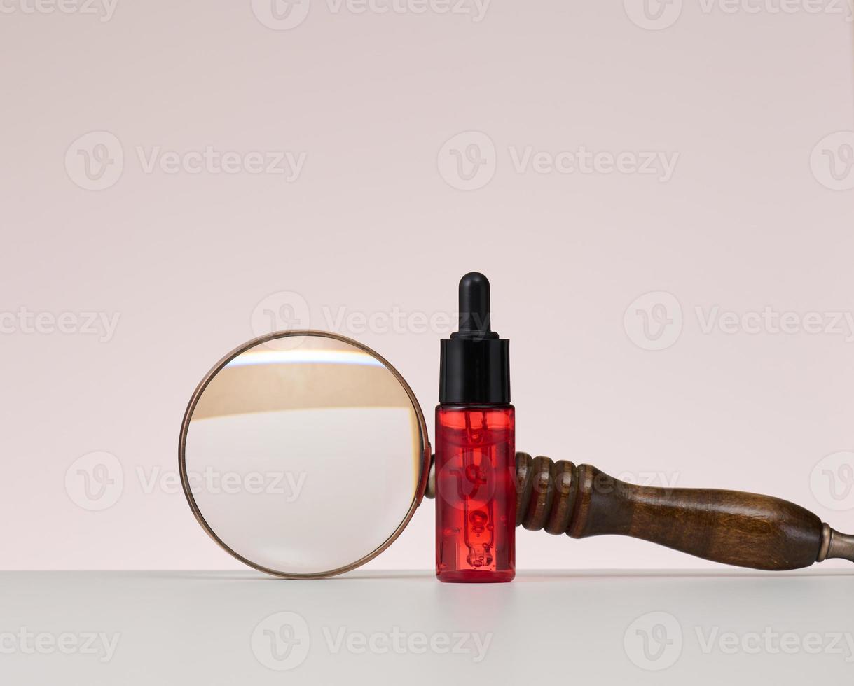 red glass bottle with pipette for cosmetics, oils and serum. Advertising and product promotion photo