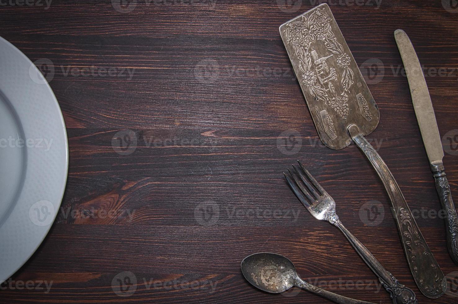 Vintage cutlery on brown wooden surface photo