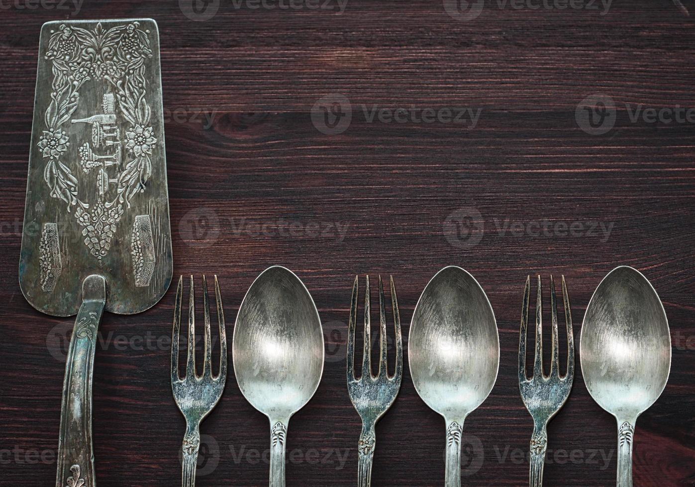 Vintage cutlery on brown wooden surface, top view, an empty space on the right photo