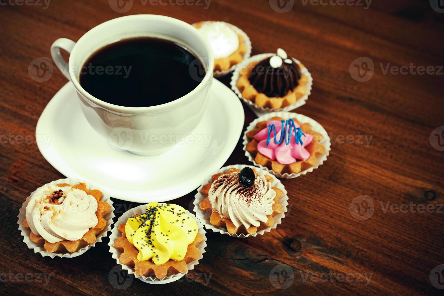 primer plano de una pequeña taza de café con cupcakes coloridos foto