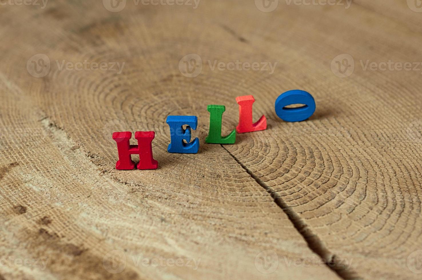 word hello from small wooden letters on a stump photo