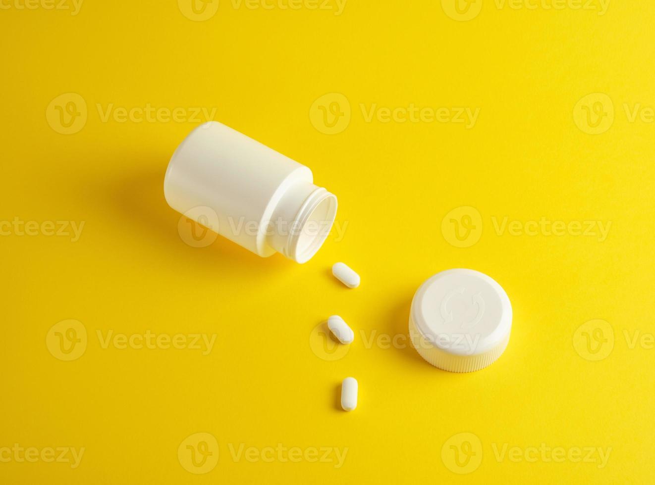 open white plastic jar for medicines and oval pills photo