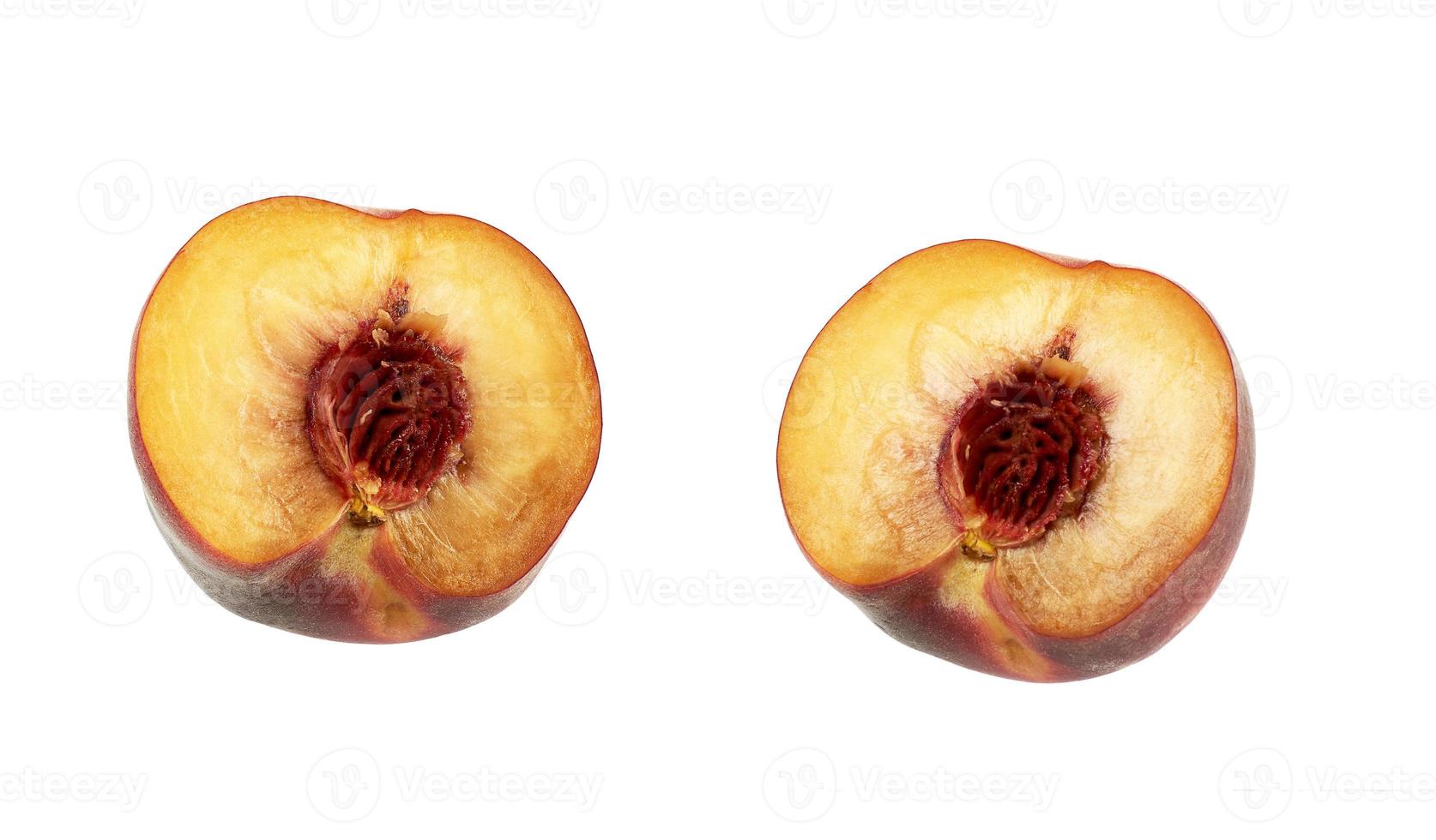 two halves of a ripe peach with a pit isolated on a white background photo