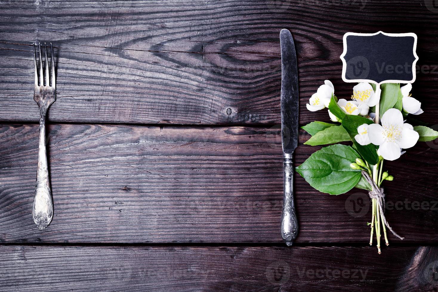 Iron fork and knife with a bouquet of jasmine photo