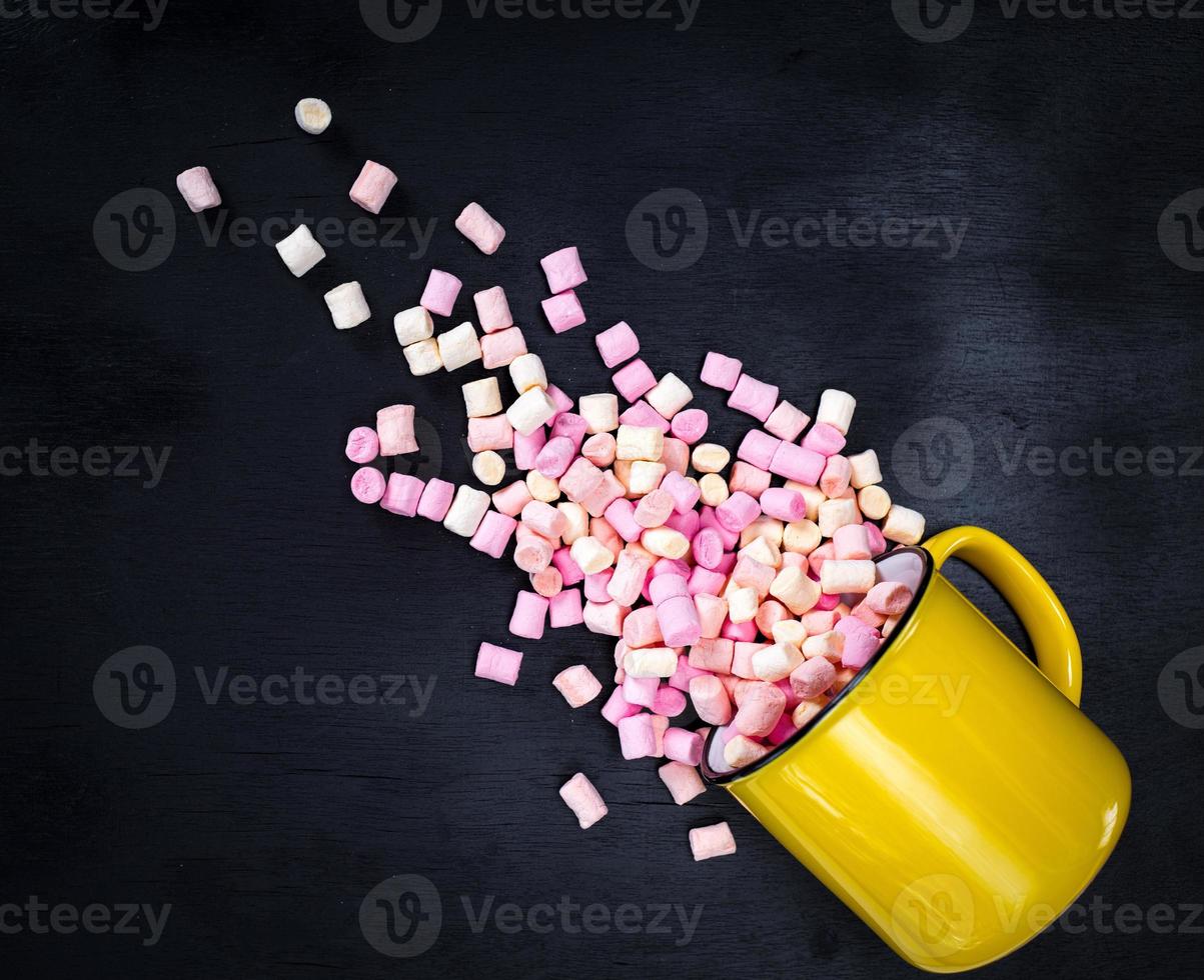 yellow mug with multicolored marshmallow photo