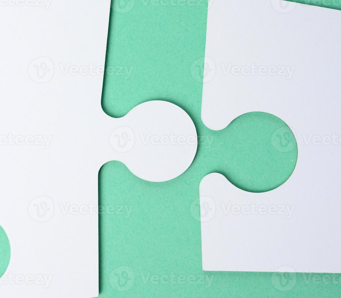 white paper puzzles on a green background, connection photo