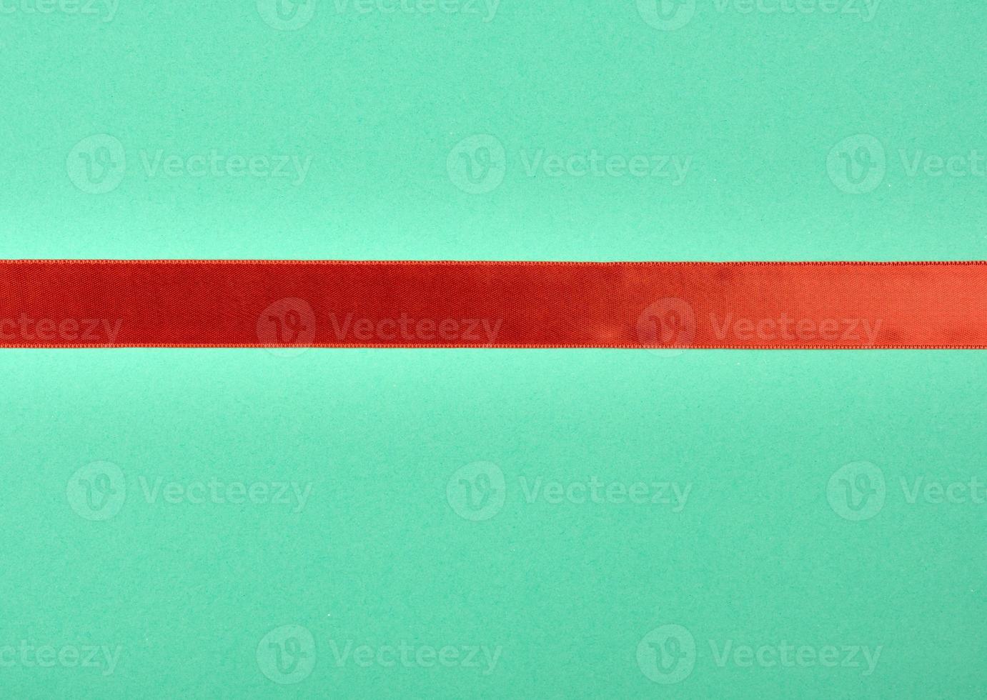red satin ribbon on green background photo