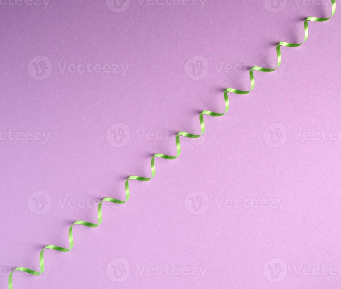 serpentina de papel verde sobre un fondo lila foto