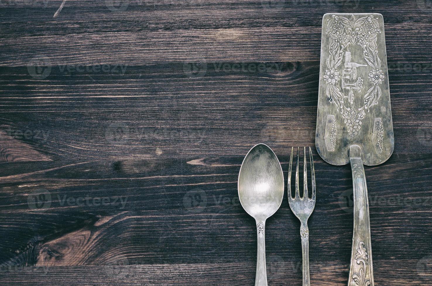 Vintage cutlery on rustic wooden background. photo