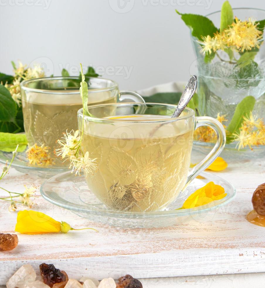 taza transparente con té de tilo en una tabla de madera blanca foto