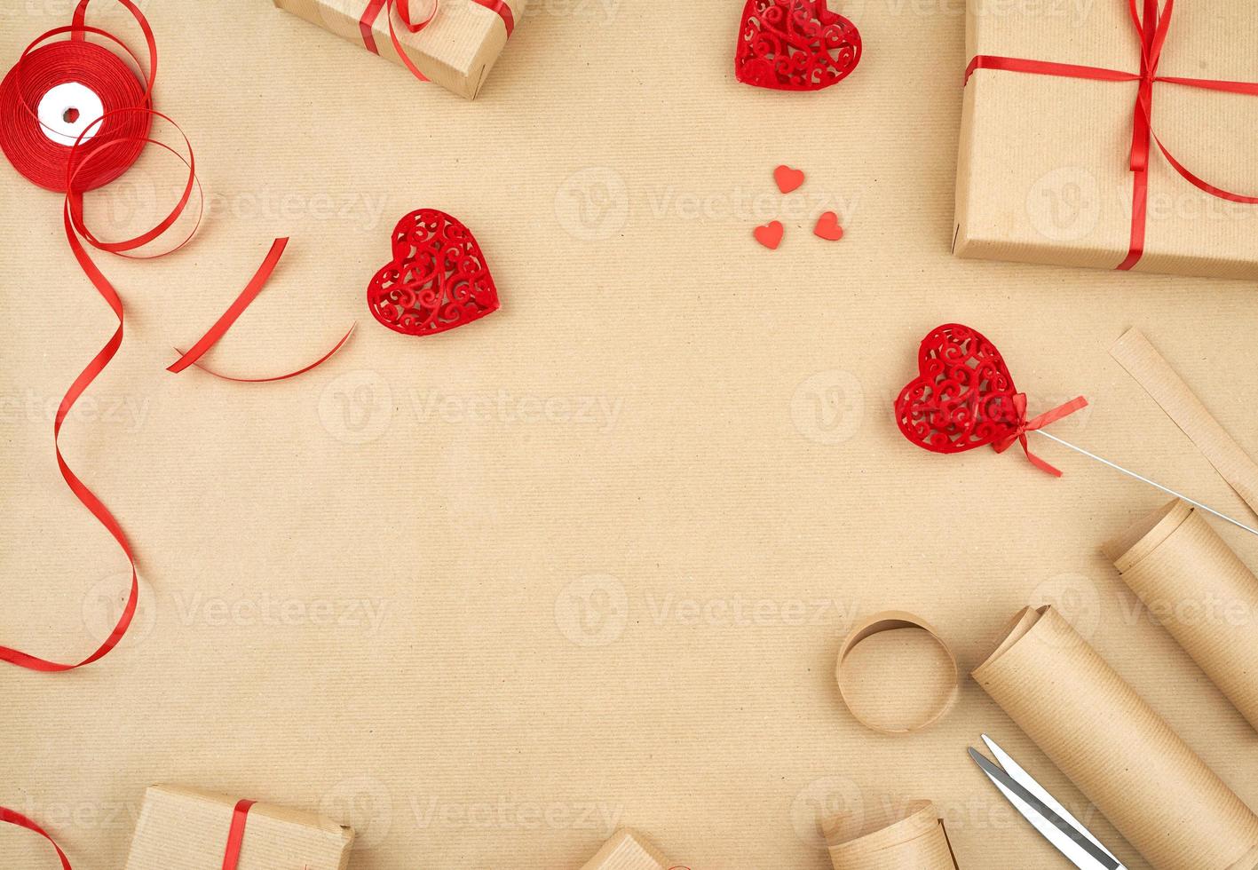 papel kraft marrón, bolsas de regalo empaquetadas y atadas con una cinta roja, corazón rojo foto
