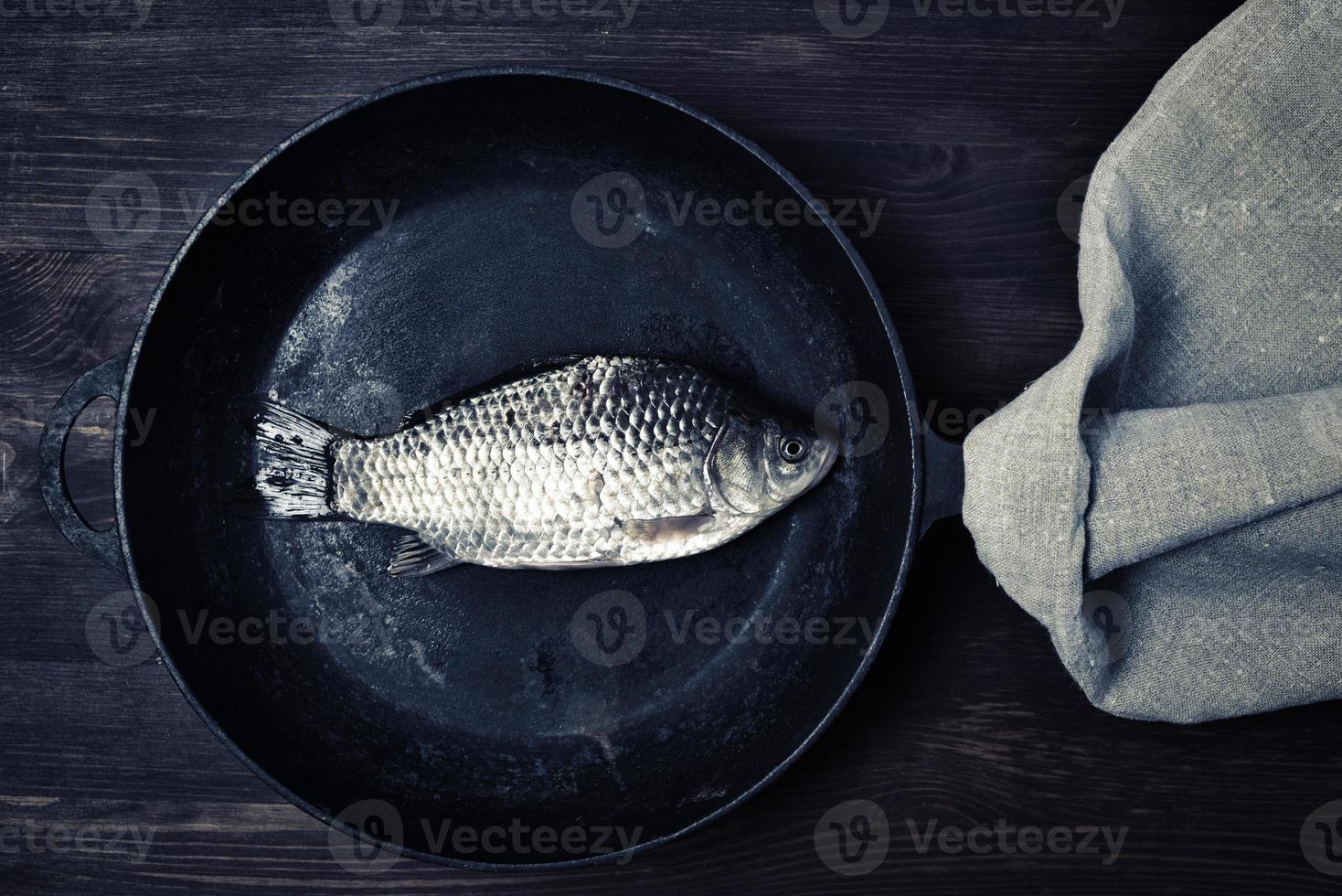 Fresh river carp in a black cast-iron frying pan photo