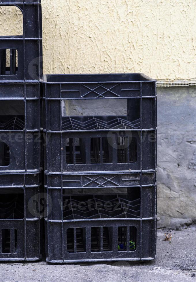 stack of empty black plastic crates photo