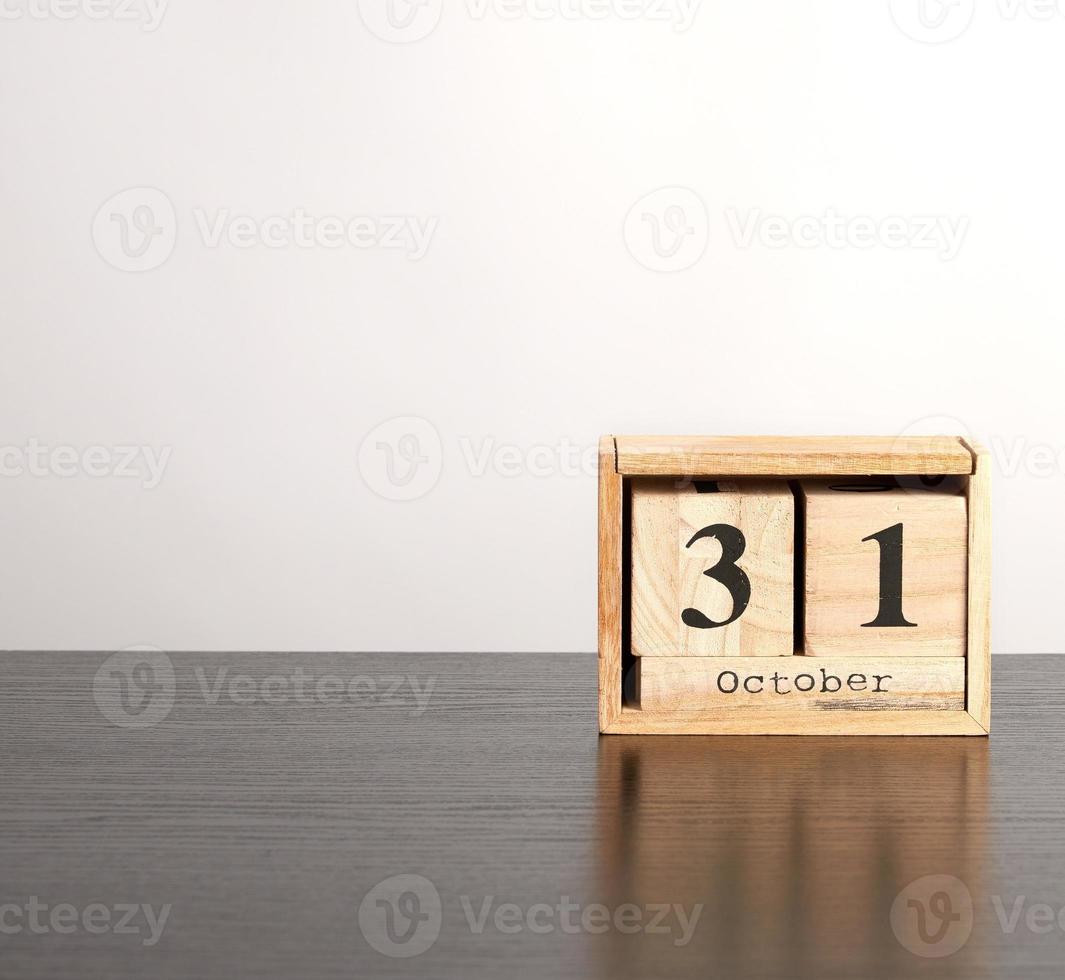 wooden calendar of cubes with the date October 31 on a black table photo