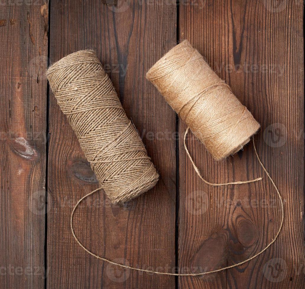 brown thread twisted into a spool on a wooden background 18964722 Stock  Photo at Vecteezy