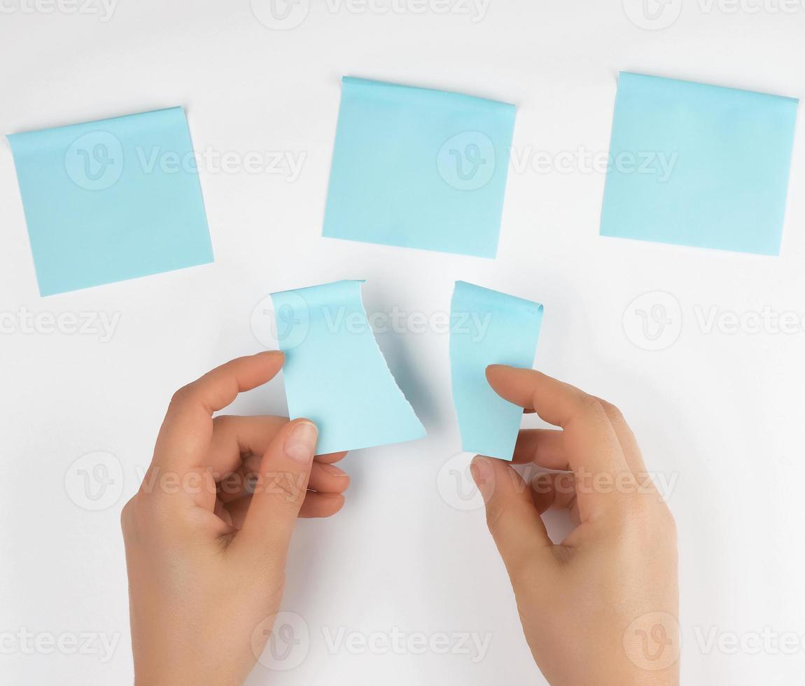 lot of blue stickers on a white background and two female hands photo