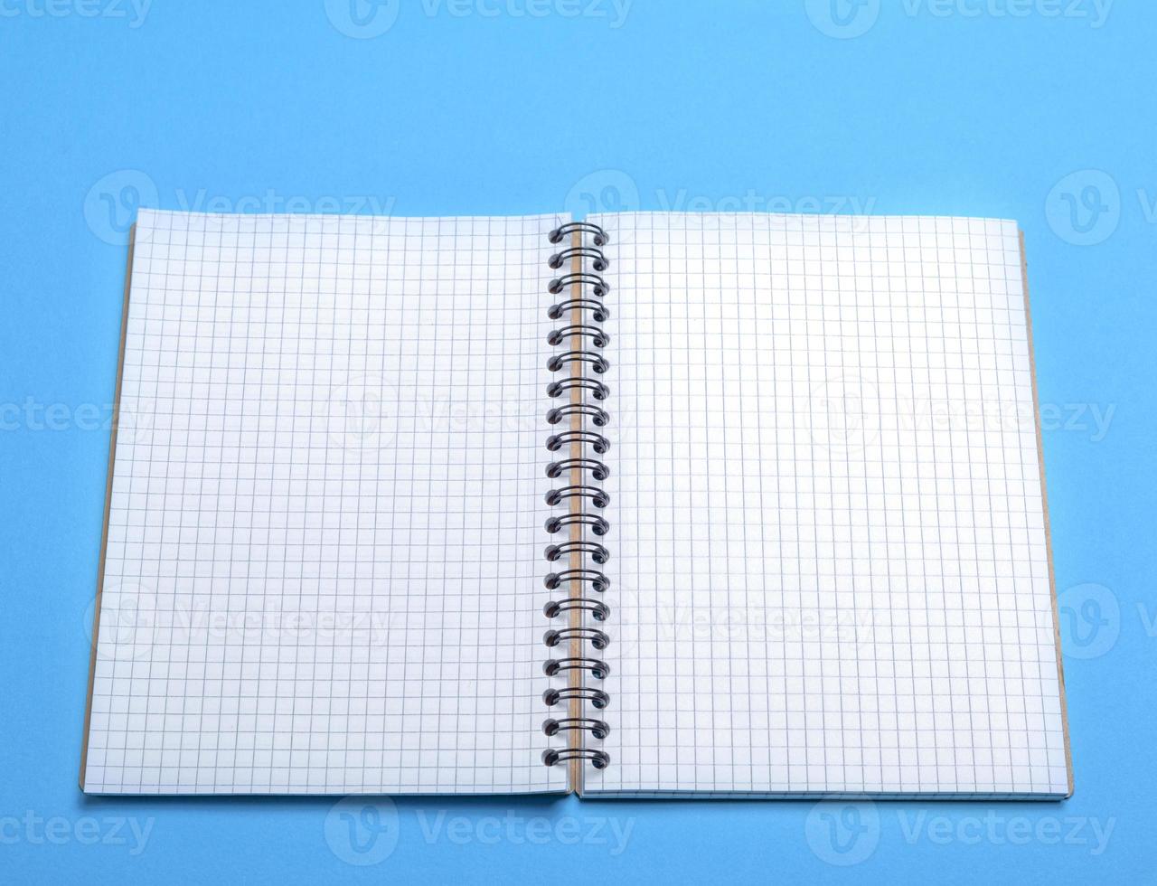 open blank notebook in a box on a blue background photo