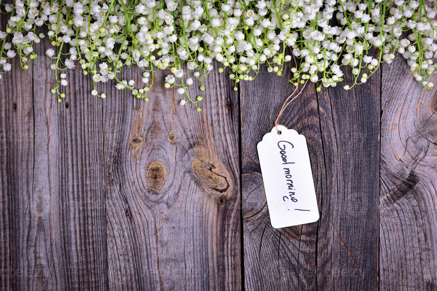 Gray wooden background with a paper tag with the inscription good morning photo