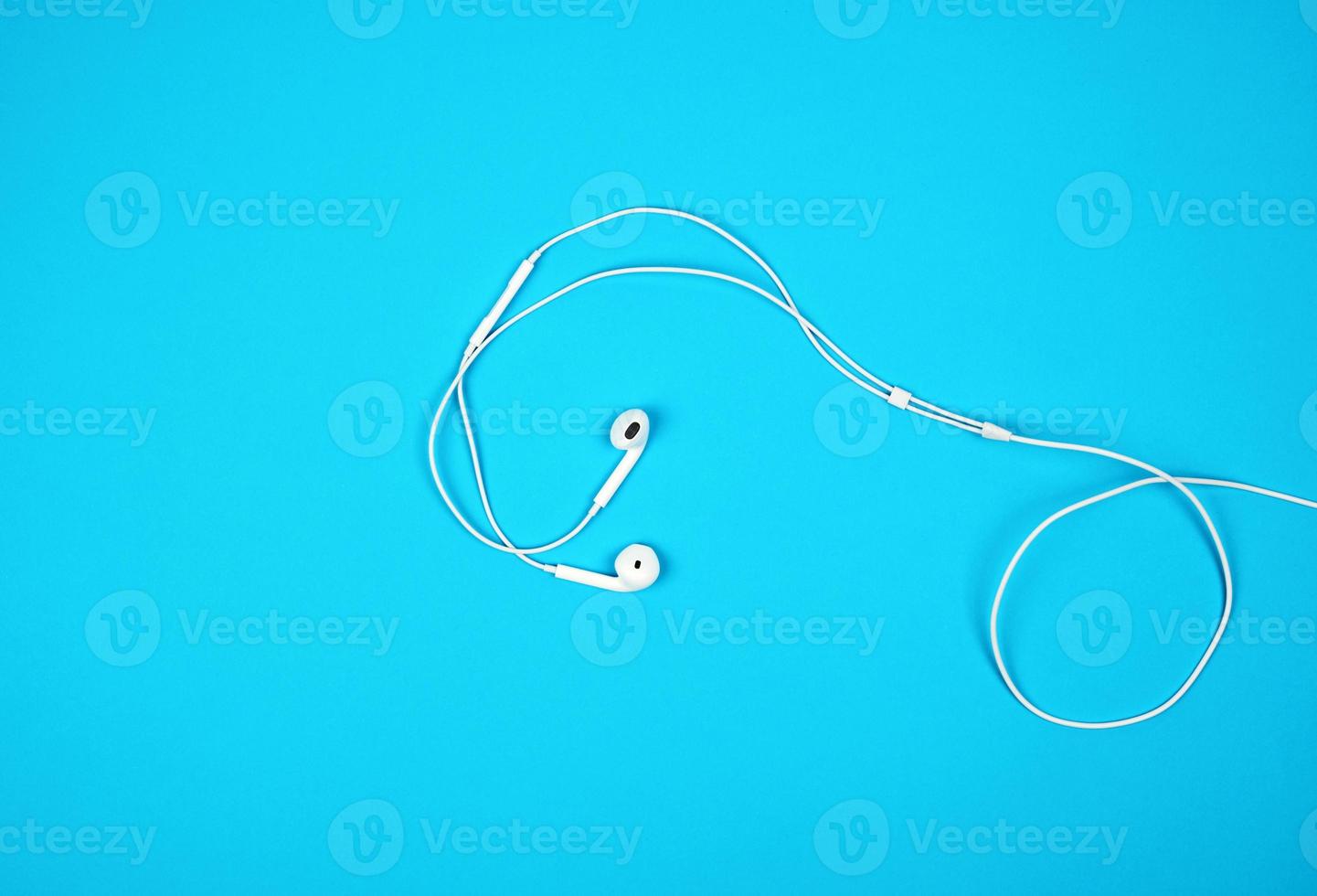 white earphones with a cable on a blue background photo