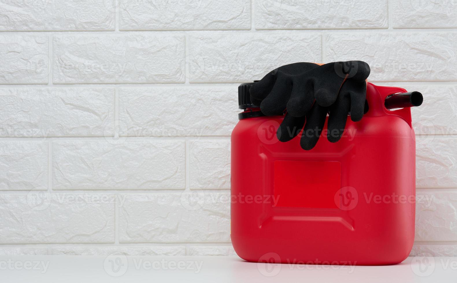 Red plastic canister for liquid fuels and lubricants on a white background photo