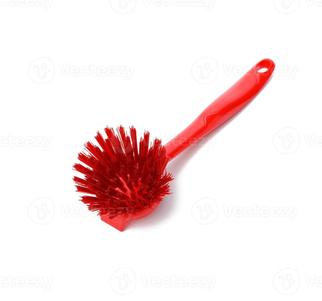 Cepillo de plástico rojo con mango para limpieza aislado sobre fondo blanco. foto