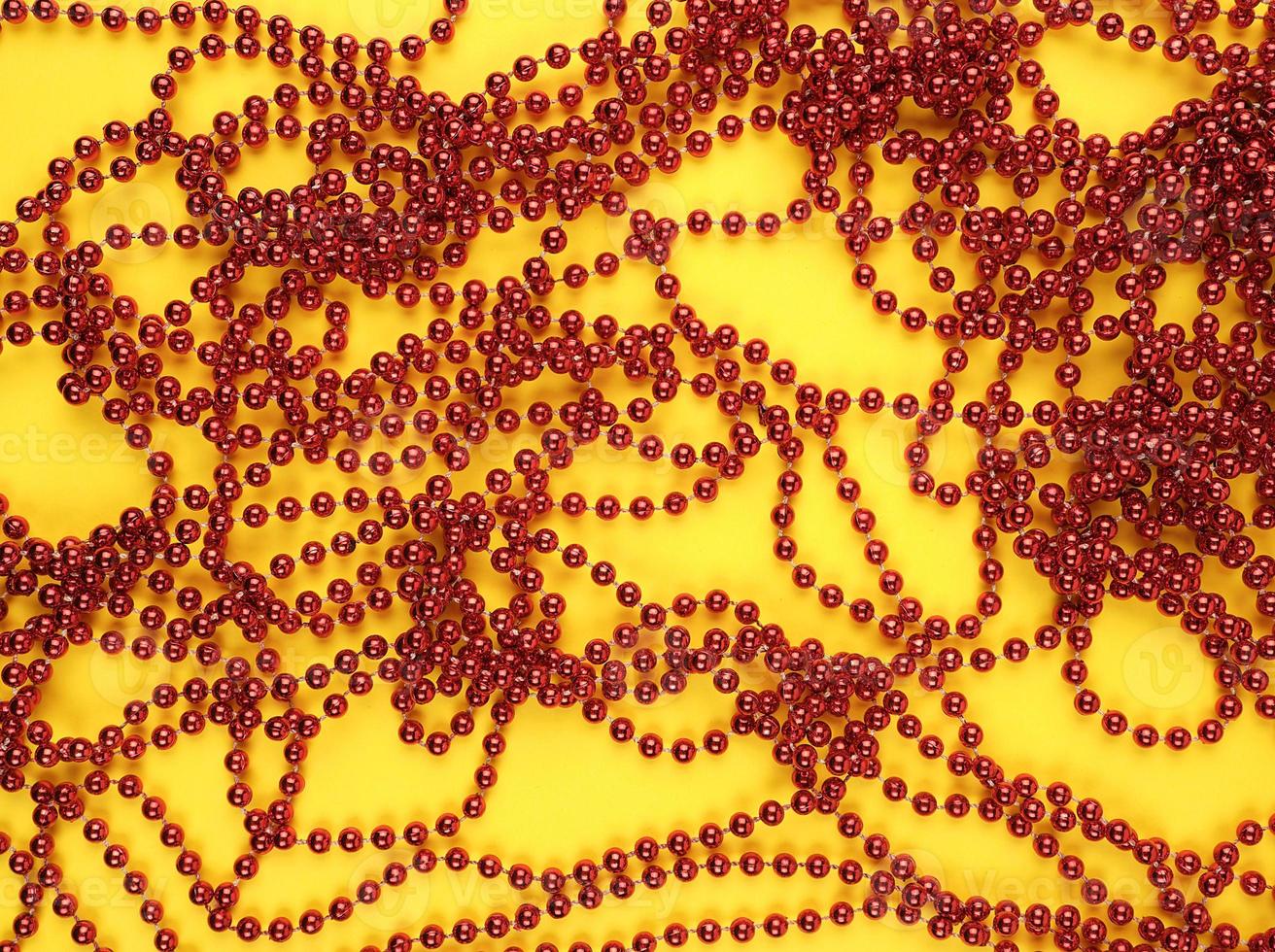 Christmas red garland of round glass balls on a yellow background photo