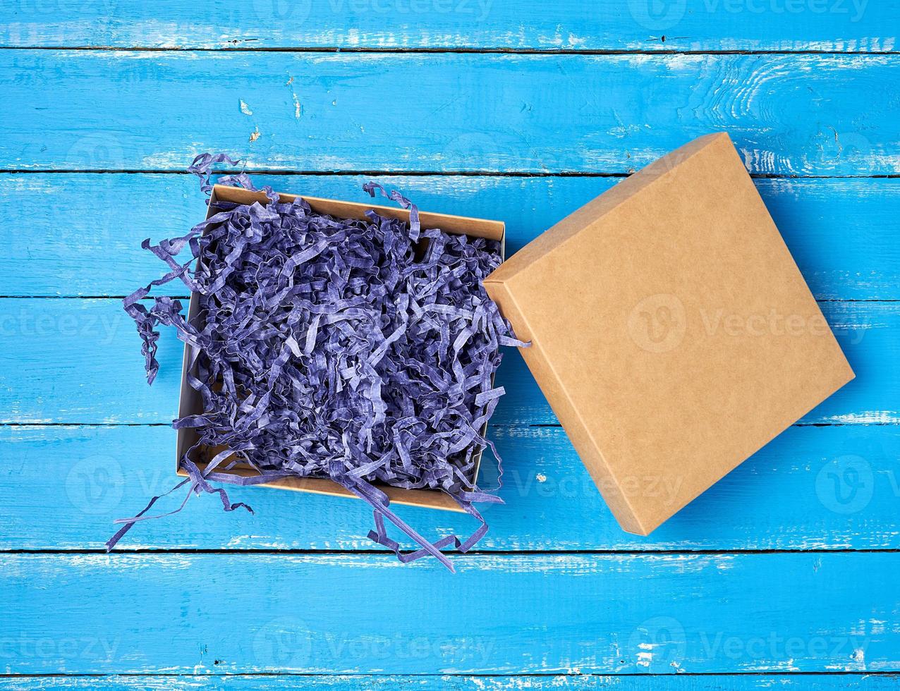 open empty brown craft box on a blue wooden background photo