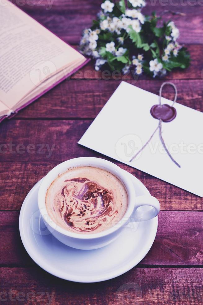 beber capuchino de café caliente en una mesa marrón foto