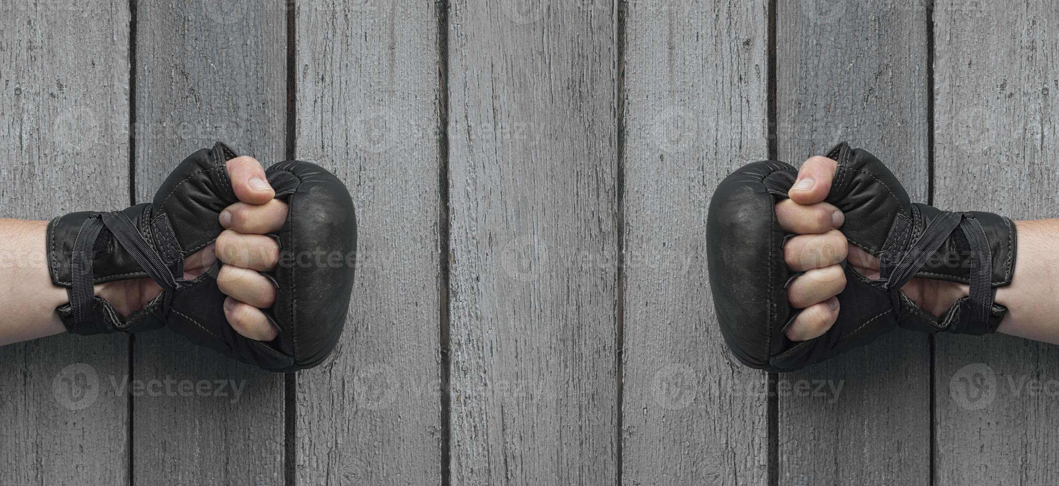 Two men hands in black leather gloves for Thai boxing photo