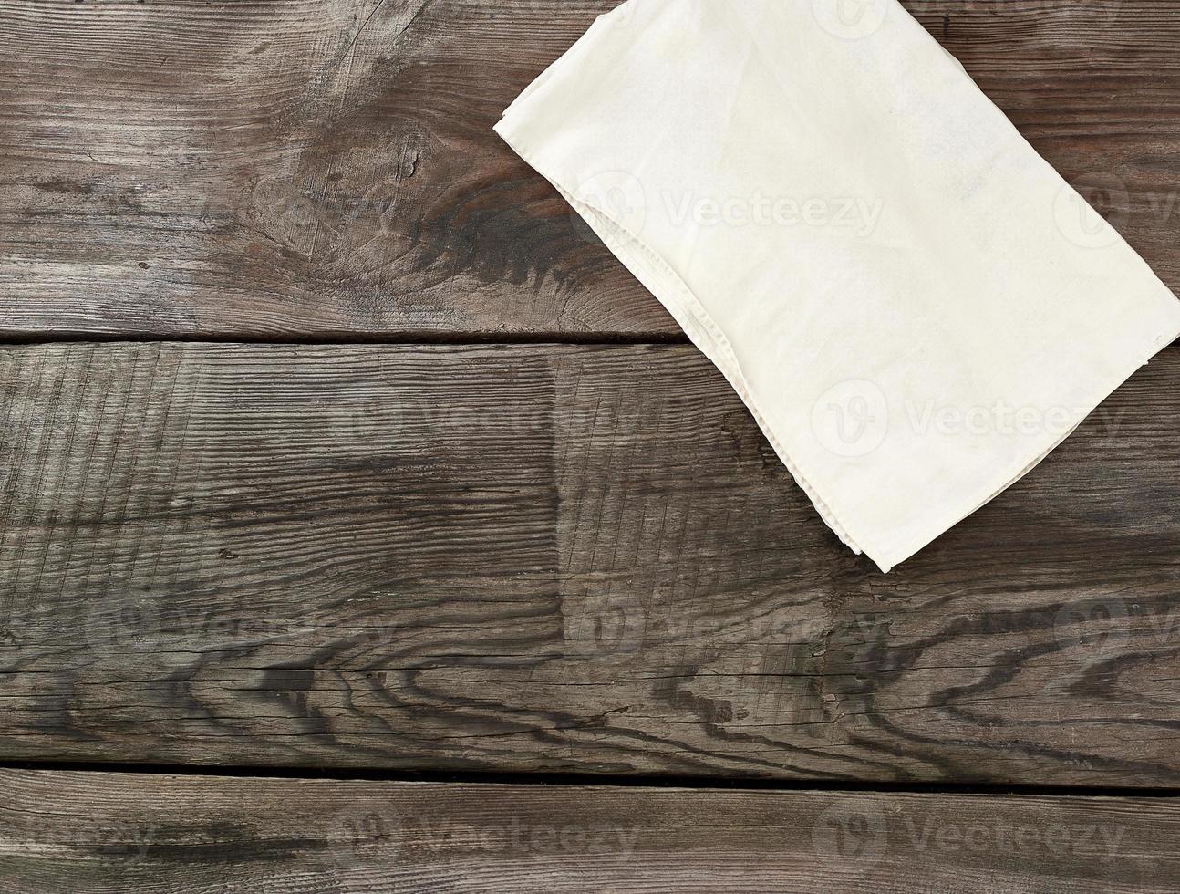 white kitchen textile towel folded on a gray wooden table from old boards, top view, empty space photo
