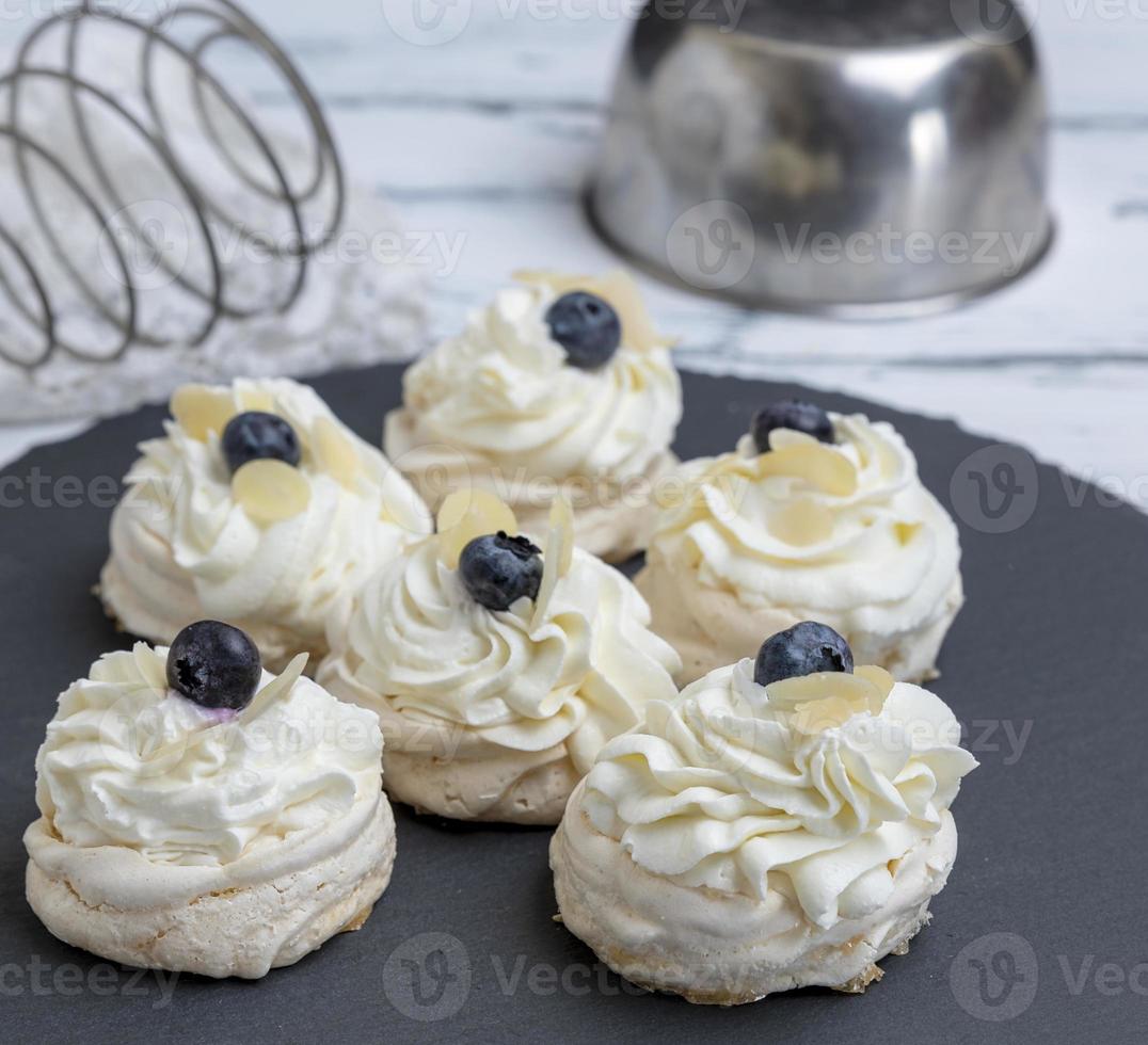 baked round meringues with whipped cream photo