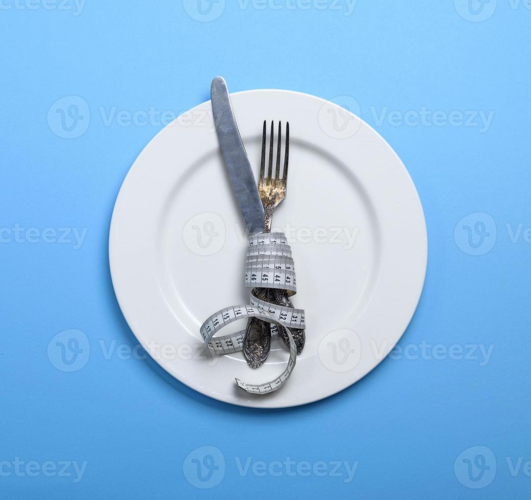 cuchillo con un tenedor envuelto en una cinta métrica foto