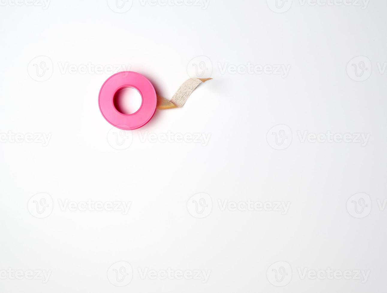 medical textile adhesive plaster for skin in a twisted, pink plastic packaging photo