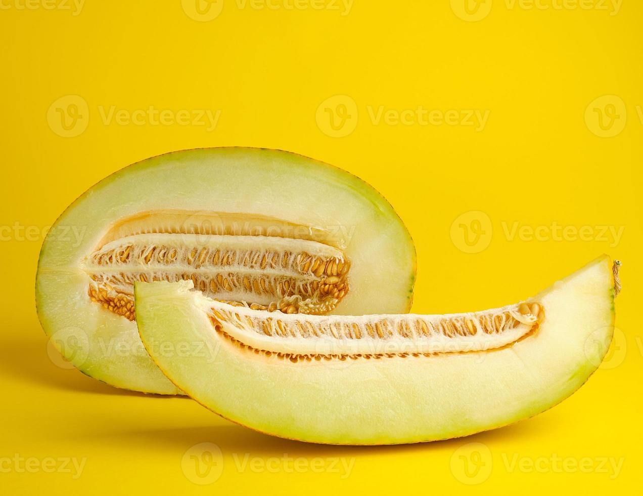 piece of ripe melon with seeds on a yellow background photo