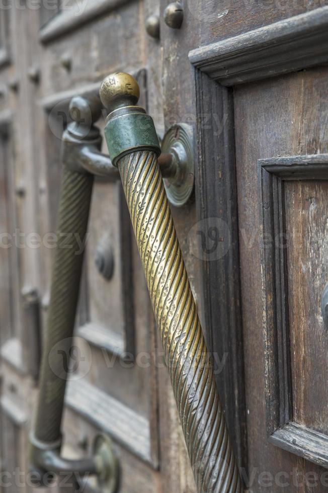 tirador de puerta de cobre en una puerta de madera marrón foto