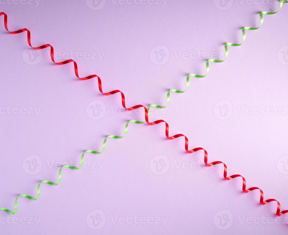 red and green paper serpentine on a lilac background photo