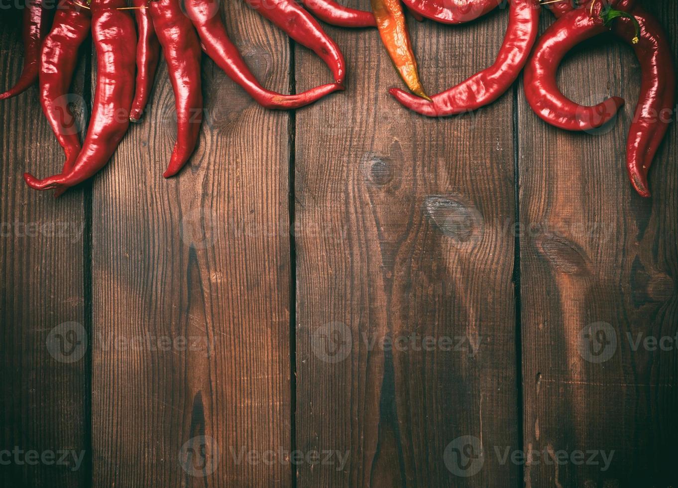 ripe red chili peppers on a brown wooden vintage background photo