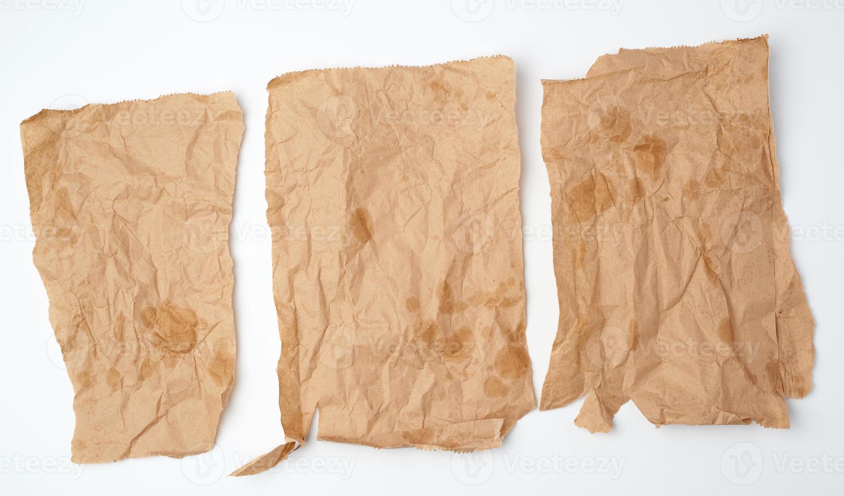 three torn crumpled pieces of brown paper with grease stains photo