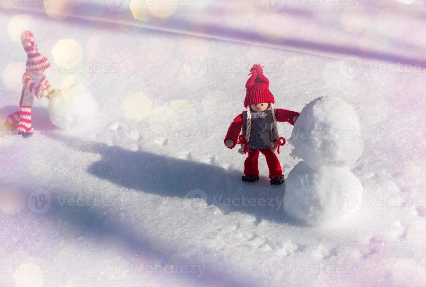 Two toy little man rolled a snowball, day photo