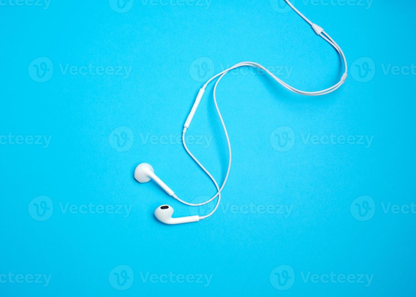 white earphones with a cable on a blue background photo