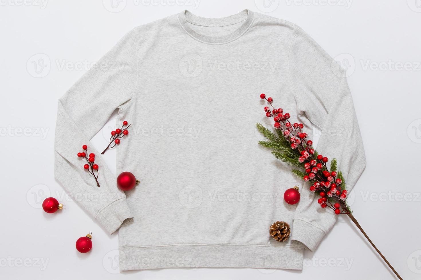 Close up blank template shirt, gray sweatshirt hoodie with copy space and Christmas Holiday concept. Top view mockup sweater isolated on white background. Happy New Year decorations. Xmas jamper photo