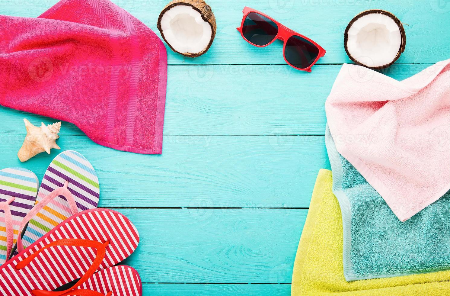 Summer accessories for modern woman on her vacation. Top view. Blue wooden background with copy space. photo