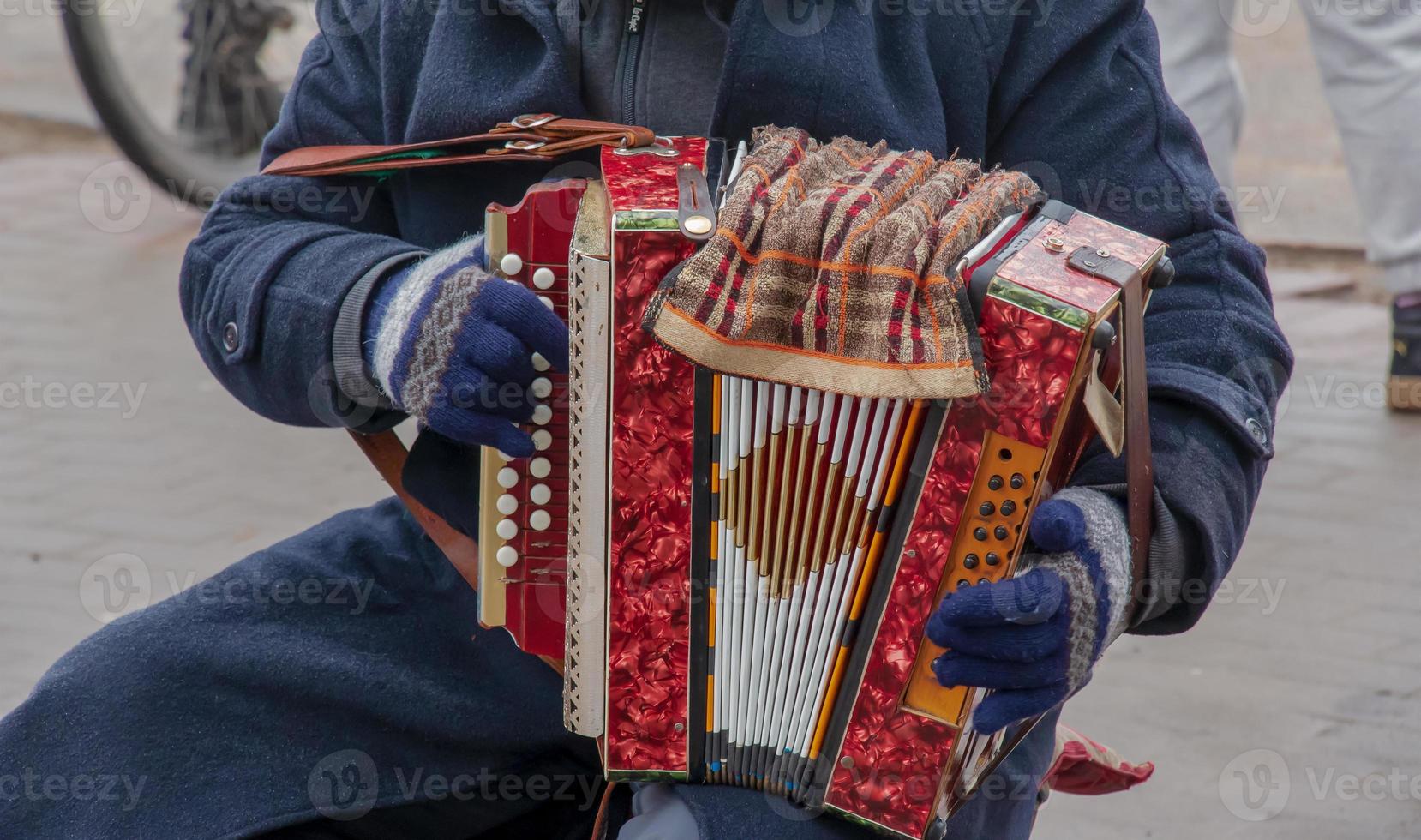 Close-up of a man's hand playing button accordion outdoors in winter. photo